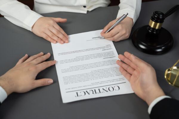 Lawyer signing contract, professional lawyer in law firm library drafting legal document or contract agreement ensuring lawful protection for client's dispute as fairness advocate concept. Equilibrium
